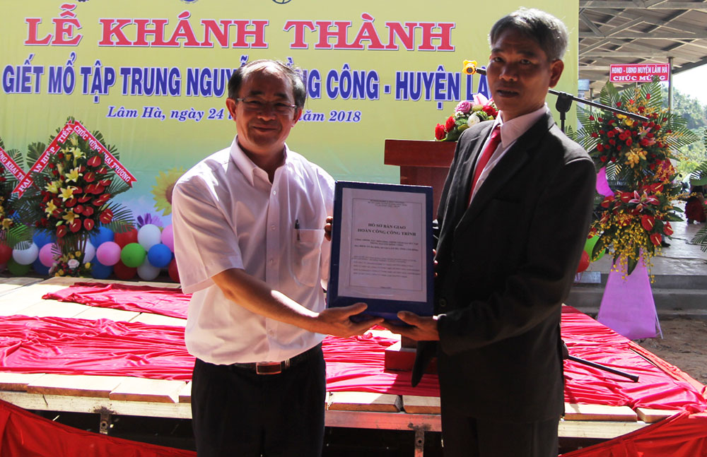 Ông Nguyễn Minh Sơn bàn giao hồ sơ hoàn thành công trình. Ảnh: H.Y